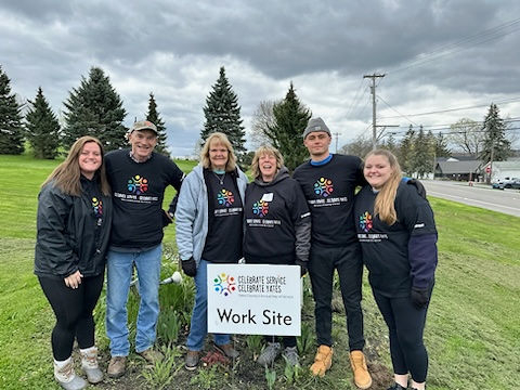 volunteers together at work site sign